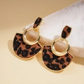 Detalle macro de pendientes colgantes de leopardo dorado con dijes redondos y en abanico - Pin de Plata Marrón Leopardo Estilo Abanico