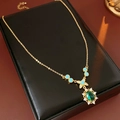 Nahaufnahme der Vintage-Goldkette mit grünem ovalem Edelstein und blauen Zirkon-Akzenten - Halskette mit ovalem Blumenanhänger / Halskette - Blau (Vergoldet)
