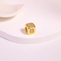 Close-up of golden square charm with zircon-studded letter B for DIY jewelry making - Letter B