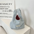 Detail der hellblauen Denim-Handtasche mit rot-weißem Karofutter und Schleifenmuster - Hellblau Schleife