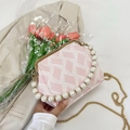 Detail of pink shell-shaped crossbody bag with pearl handle and golden chain strap - Diagonal Pattern / Pink