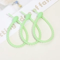 Detail of light green silicone cable ties with notched design and buckle head - Luminous Cyan