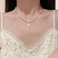 Detail of vintage tulip flower necklace with white oval pearl pendant on a gold chain - White Flower