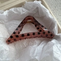 Detailed view of a red-brown triangular hair claw clip with black polka dots on tissue paper - Coffee Black Polka Dot / Triangle Style