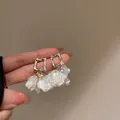 Détail de boucles d'oreilles dorées avec pétales blancs et accents de gemmes - Pendentif pétale à cadre doré (4#)