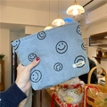 Detail of light blue corduroy pouch with smiling face prints held by hand in-store - Light Blue Gray Smiley Face