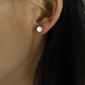 Minimalist white round bead stud earring shown on a model's ear for size comparison - 5mm / White