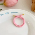Pink knitted elastic hair tie with bow ornament and gold clasp in a stylish setup - Pink