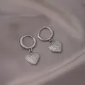 Silver hoop earrings with sparkling heart-shaped pendants on soft silk background - E-050---Platinum