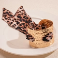 Macro detail of gold hammered metal cuff bracelet with leopard print silk ribbon knot - Gold Cuff With Leopard Print Scarf