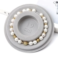 Elegant white faux pearl bracelet with golden flower beads on 19cm display tray - Flocked Plastic / Grey Sizing Tray (19cm)