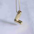 Detailed view of polished gold alphabet L letter pendant with glossy mirror finish - L