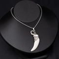 Detailed shot of vintage silver elephant head pendant with a white curved fang on black model - Elephant Head with White Tooth