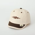 Detail van de geborduurde Coffee-tekst en merklabel op de tweekleurige kinderpet - 52cm (2-5 Jaar) / Broken Wit
