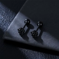 Close-up of matte black rose stud earrings with screw ball back on grey leather background - Single Piece / Black Large