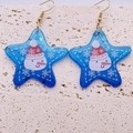 Detail of star-shaped Christmas earrings with snowman pattern on blue acrylic - Blue Star Snowman