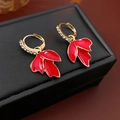 Macro shot of maple leaf earrings with red enamel finish and sparkling crystals - Red Hoop Buckle