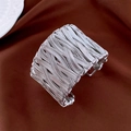Detail view of wide silver twisted metal cuff bracelet with woven texture on red velvet - Silver
