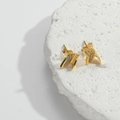 Detailed macro view of golden butterfly stud earrings with micro-pave cubic zirconia crystals - Butterfly