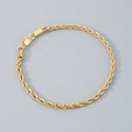 Bracelet chaîne torsadée en acier titane doré avec fermoir mousqueton sur fond gris - Bracelet 21cm / 3mm / Or