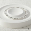 Detailed close-up of a 4mm silver stretch metal bead bracelet on a white display tray - 4mm / Silver