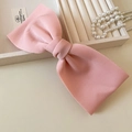 Detalle del pasador de pelo con lazo grande rosa de tela con textura de terciopelo suave - Rosa
