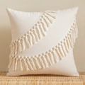 Beige bohemian tassel pillow cover with hand-woven wavy fringes on a rattan bench - Ceremonial Tassel