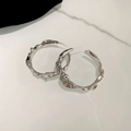 Pair of silver-tone irregular lava texture hoop earrings on white marble background - Irregular Lava (HE8275) / Silver