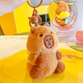 Plush brown capybara keychain featuring a yellow bee backpack and a brown bell - With Bee Backpack