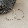 Detail of silver hoop earrings with wavy hammered texture on warm knit background - 30# Steel Post - Silver - Textured Hoop