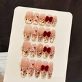 Unghie finte sfumate rosa con fiocchi di velluto rosso, disegni di conigli e glitter oro - L