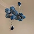 Detalle de pendientes de flor bordada y cristal azul con pasadores de corazón de circón - Azul