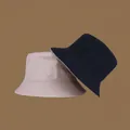 Detail of beige and navy reversible bucket hats showing canvas material and wide brim - M (56-58cm) / Apricot & Black