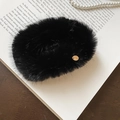Close-up of black faux fur hair tie with gold charm on vintage book aesthetic - Duckbill Hair Clips / Black