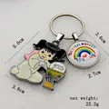 Macro detail of rainbow school-themed metal keychain with angel charm for kids - Ivory