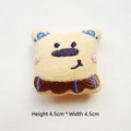 Detail view showing a 4.5cm cream plush bear brooch with colorful embroidery - Yellow Dog With Scarf