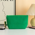 Detail van groene badstof make-uptas met textuurstof en metalen ritssluiting dichtbij - Groen