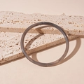 Detalle de brazalete acrílico gris translúcido en una piedra de travertino natural - Brazalete-Gris
