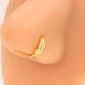 Macro shot of a gold leaf nose ring on a skin model with detailed feather texture - E4612-1/Gold/Feather Shape
