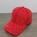 Detailed macro view of vibrant red baseball cap with colorful rhinestone embellishments - Red