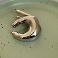 Nahaufnahme der silbernen Halbmond-Brosche mit polierter Oberfläche auf Keramik - Silber