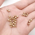 Detailed view of polished golden CCB spacer beads for DIY jewelry making on a hand - Round Spacer Bead (14149)