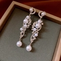 Primer plano de pendientes largos con borlas de perlas y cristales en joyero de terciopelo - Plata (Pin de plata)