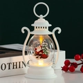 Detalle de farol navideño blanco con Papá Noel y luces LED cálidas en escritorio festivo - Papá Noel blanco