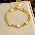 Nahaufnahme vom Goldnetz-Armband mit drei quadratischen Zirkoniasteinen auf Schmuckbox - Weißer Edelstein-Stil (B1967)