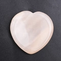 Natural rose quartz heart-shaped thumb stone on black textured background - Pink Aventurine