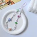 Close-up of pastel beaded phone strap with tulip charms on a white ceramic tray - Colorful