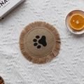 Handwoven round jute placemat with black paw print pattern and fringe tassels - Type D Jute Coaster