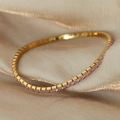 Tennis bracelet with pink zircon stones in a gold plated finish on satin fabric - Gold/Pink Zirconia