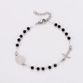 Detail of religious bracelet with black faceted beads, cross charm and medal - Steel